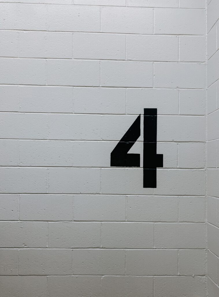 The number 4 spray painted on a white concrete wall