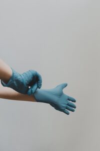 A doctor puts on a pair of blue gloves
